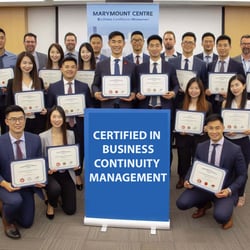 A professional certification ceremony at Marymount Centre where the BCM team receives recognition for completing training. Participants hold their certificates proudly, while a banner behind them reads Certifie