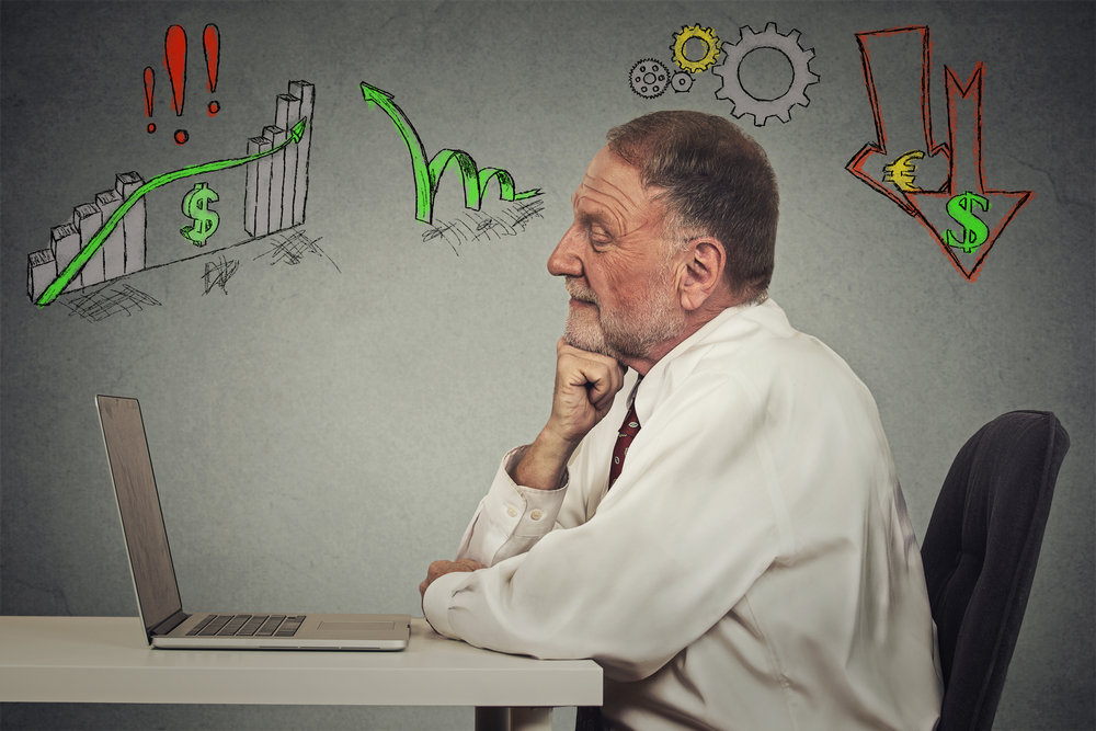 Side profile view senior business man working on computer isolated on grey wall background. Anticipation of financial crisis, bad, poor economy concept. Corporate employee thinking, making decisions.
